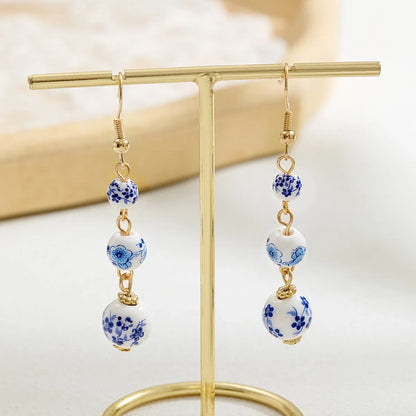 Long retro earrings with blue and white porcelain ceramic beads and geometric alloy construction