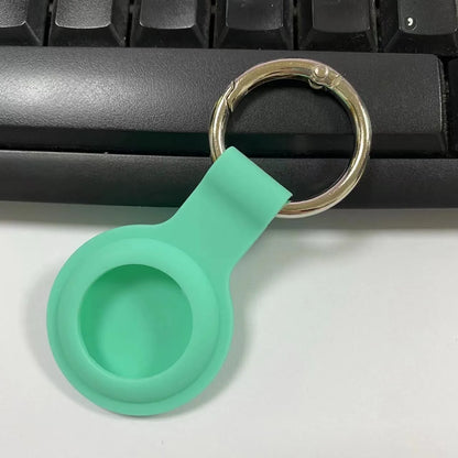 Black waterproof silicone Airtag protective case with metal keychain clip, shown next to colour options.